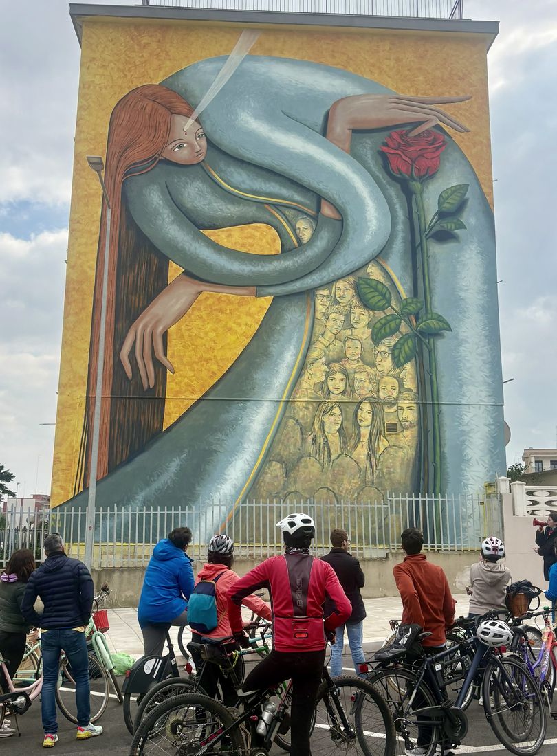 Cyclists stopped in front of a large mural during a Terreno ride